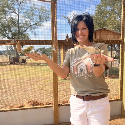 a young girl standing in front of a fence