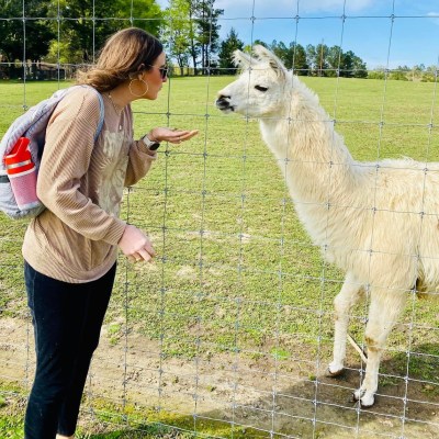 a woman standing next to a sheep